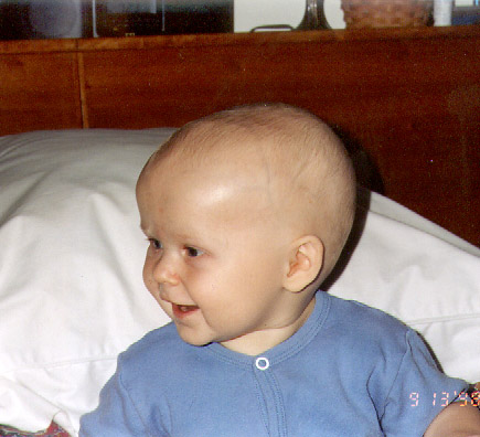 Happy baby sitting up in bed